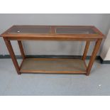 A two tier hall table with glass inset panels