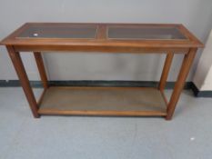 A two tier hall table with glass inset panels