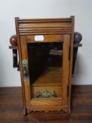 An Edwardian oak smokers cabinet with pipes