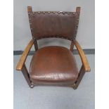 An Edwardian oak child's armchair in button leather