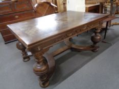 An early 20th century carved oak pullout dining table on bulbous legs