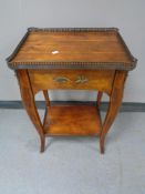 A reproduction French style bedside table with brass gallery and mounts