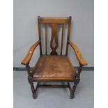 An Edwardian oak carver armchair