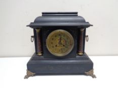 A late nineteenth century French ebonised mantel clock on brass paw feet