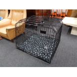 A folding black metal dog cage,