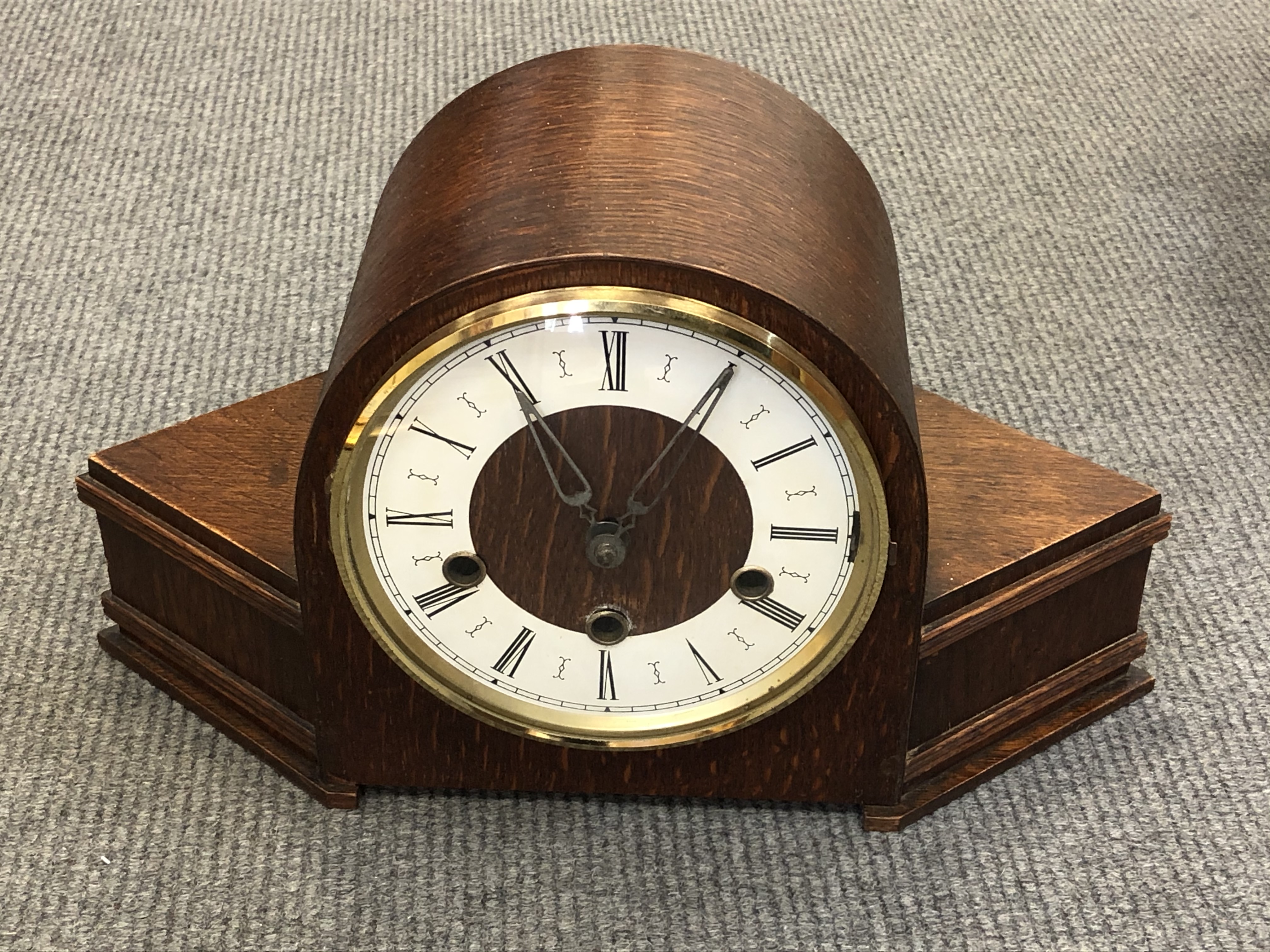 An Art Deco oak cased mantel clock with pendulum and key