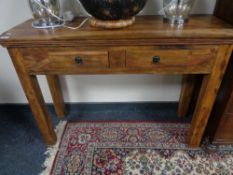 A sheesham wood side table fitted with two drawers