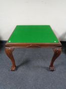 An Edwardian baize topped card table on claw and ball feet