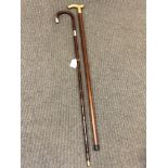 An antique silver mounted walking cane together with a brass mounted 'tipple' stick.