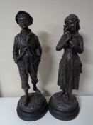 A pair of early 20th century spelter boy and girl figures on wooden bases,