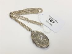 A silver locket with engraved decoration on silver chain