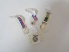 Four miniature medals on ribbons - George V long service & good conduct, St. Michael & St.