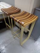 A good quality pair of mixed wood bar stools on painted metal bases