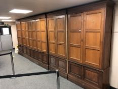 An impressive oak gun-room cabinet, the nine panel doors with breakfront on cupboard base,