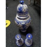 A blue and white earthen ware lidded urn together with a pair of candlesticks