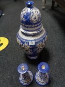 A blue and white earthen ware lidded urn together with a pair of candlesticks