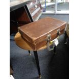 A vintage brown leather suitcase and a lamp table