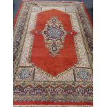A fringed Eastern carpet on red ground CONDITION REPORT: 300cm by 208cm.