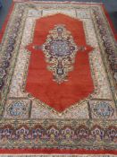 A fringed Eastern carpet on red ground CONDITION REPORT: 300cm by 208cm.