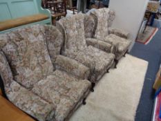 Three upholstered armchairs in floral fabric