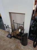 A contemporary fire surround, metal insert grate and fire side accessories.