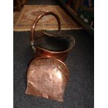 An antique copper coal helmet and copper scoup