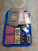 A tray of miniature binoculars, gramophone needle tins, maps for trams,