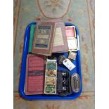 A tray of miniature binoculars, gramophone needle tins, maps for trams,
