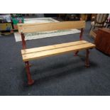 A cast iron bench with reclaimed pine seat and back