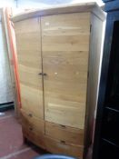 An oak bow fronted wardrobe fitted with four drawers