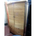 An oak bow fronted wardrobe fitted with four drawers