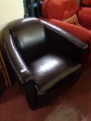 A brown stitched leather tub chair