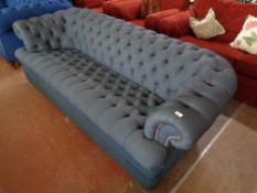 A contemporary stitched blue upholstered Chesterfield style three seater settee