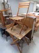 A wooden folding picnic table and two chairs