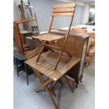 A wooden folding picnic table and two chairs