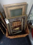 A wicker crate of antique and later picture frames and a large piece of glass