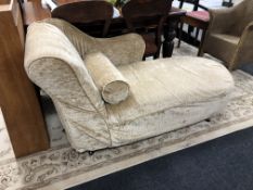 A contemporary chaise longue with fabric covering and bolster cushion