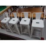 Four white metal bar stools