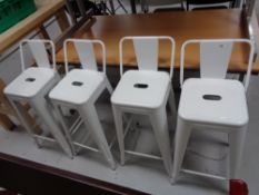 Four white metal bar stools