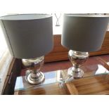 A large pair of contemporary silvered metal table lamps with shades