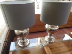 A large pair of contemporary silvered metal table lamps with shades
