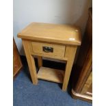 A light oak single drawer table