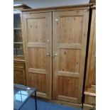 A pine double door wardrobe fitted with internal drawers