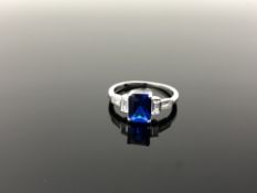 A Sterling silver Art Deco style emerald cut ring set with a blue stone, size N.