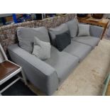 A contemporary three seater settee in grey fabric with scatter cushions