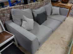 A contemporary three seater settee in grey fabric with scatter cushions