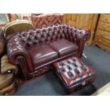 A Burgundy leather two seater Chesterfield settee and matching storage footstool