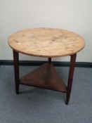 An antique circular pine table on tripod base