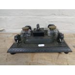 An early twentieth century ebonised desk stand with two ink wells