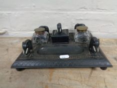 An early twentieth century ebonised desk stand with two ink wells